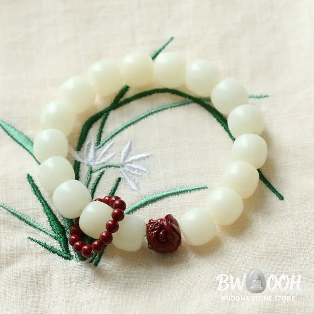 Close-up of BWOOOH Natural Bodhi Seed Wrist Mala with vibrant red Cinnabar beads and a detailed Dancing Lion charm on an elastic string, symbolizing wisdom, harmony, and protection during meditation practices. - View 4