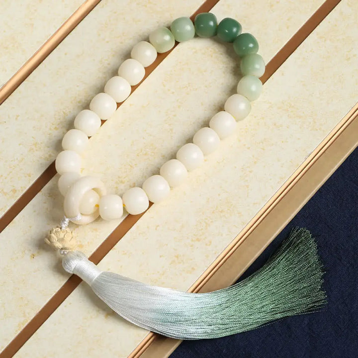 BWOOOH Natural Gradient Bodhi Seed Fortune Money Bag Lotus Wisdom Tassel Wrist Mala featuring 12mm dark-speckled bodhi seeds, boxwood, agate, and green aventurine; a handcrafted spiritual meditation bracelet for wisdom and calm. - View 12