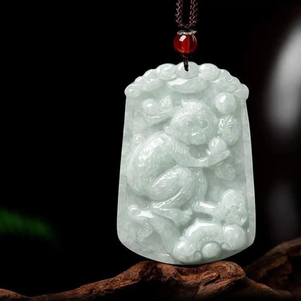 A BWOOOH Natural Jade 12 Chinese Zodiac Abundance Amulet Pendant Necklace, featuring intricate carvings of animals like the Dragon and Tiger, symbolizing prosperity and spiritual balance. The jade stone is polished, reflecting light and emphasizing its natural beauty. - View 22
