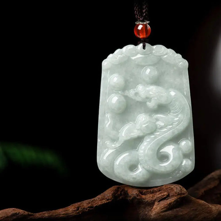 A BWOOOH Natural Jade 12 Chinese Zodiac Abundance Amulet Pendant Necklace, featuring intricate carvings of animals like the Dragon and Tiger, symbolizing prosperity and spiritual balance. The jade stone is polished, reflecting light and emphasizing its natural beauty. - View 19