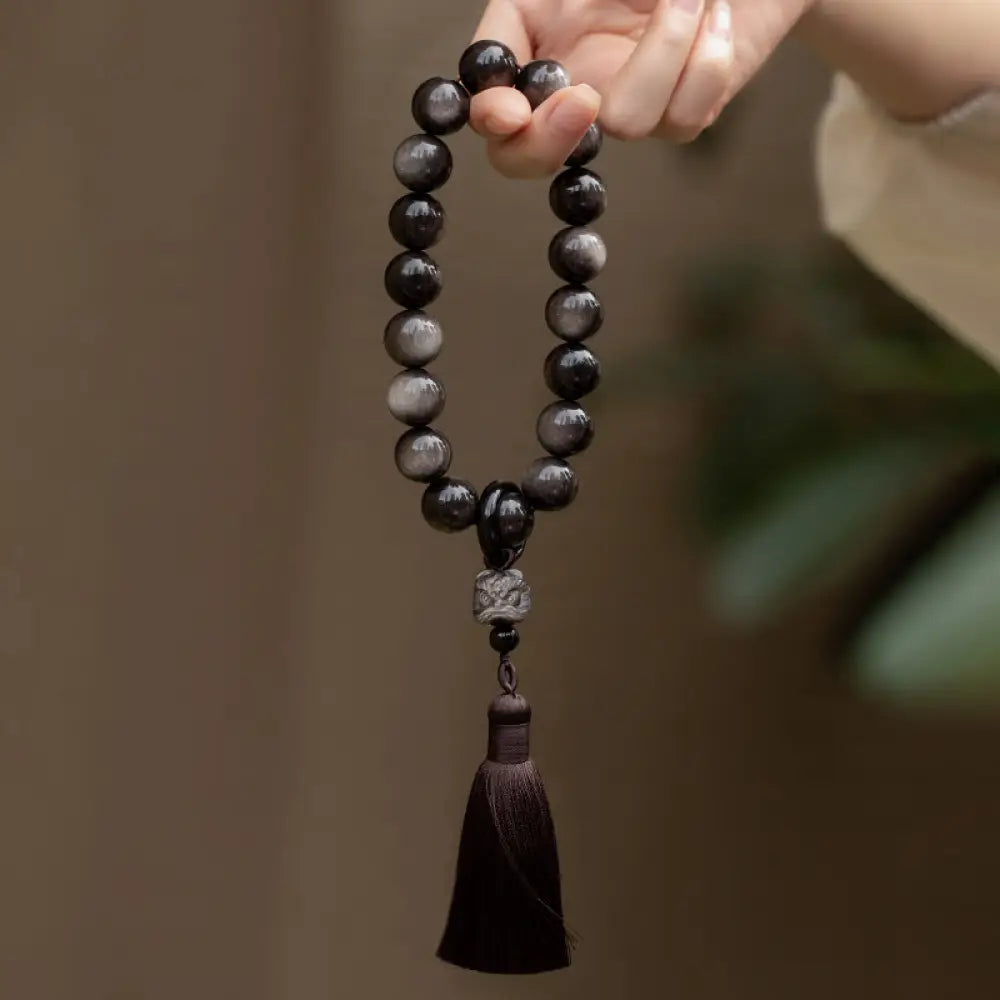 BWOOOH Natural Silver Sheen Obsidian and Black Obsidian Lion Wrist Mala with Tassels. 14mm/16mm beads, 16*15*15mm lion, for protection, courage, and positive Feng Shui energy.