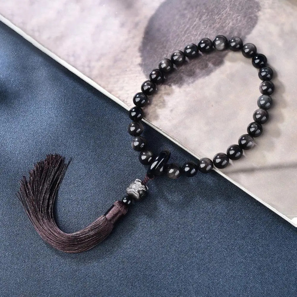 BWOOOH Silver Sheen Obsidian Lion Wrist Mala, polished beads (12-16mm), carved lion, tassels. Offers energetic protection, also a pocket mala or car decoration. - View 2