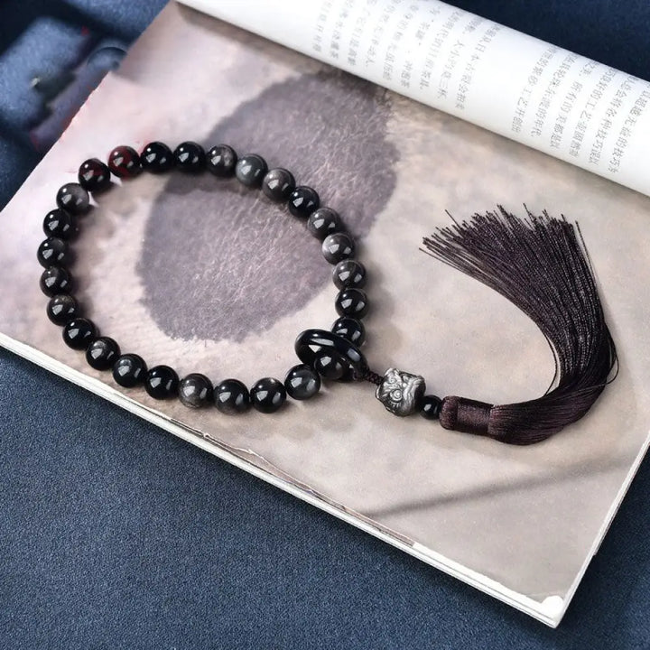 BWOOOH Silver Sheen Obsidian Lion Wrist Mala, polished beads (12-16mm), carved lion, tassels. Offers energetic protection, also a pocket mala or car decoration. - View 3