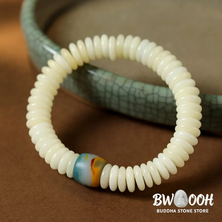BWOOOH Natural White Bodhi Seed Wisdom Tassel Wrist Mala Bracelet, featuring dark-speckled Bodhi seeds (3x10mm) with a white copper accent and soft tassel, on a 14-15cm elastic string. Ideal for meditation and spiritual balance. - View 2