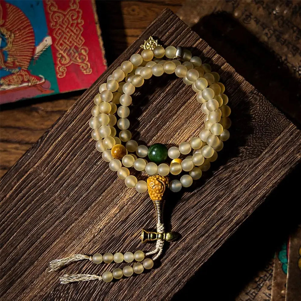 BWOOOH Tibet 108 Mala Beads bracelet featuring natural sheep horn, tiger eye, and Hetian jade with a silver Chinese Zodiac Natal Buddha charm. Sacred amulet for meditation, wealth, protection, and spiritual guidance against negative energy. Elastic string, unisex, 14-16cm wrist.