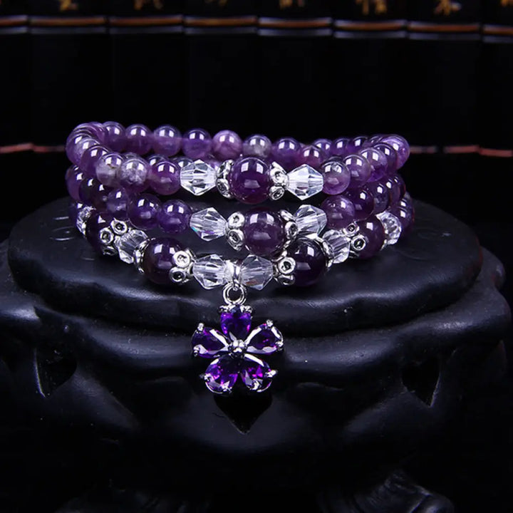 A close-up of the BWOOOH handcrafted Tibetan Amethyst Blessing Bracelet featuring lustrous 6mm natural purple amethyst beads and silver-plated copper accents, symbolizing spiritual protection and inner peace.