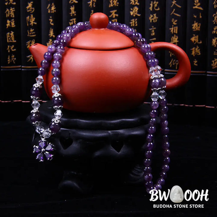A close-up of the BWOOOH handcrafted Tibetan Amethyst Blessing Bracelet featuring lustrous 6mm natural purple amethyst beads and silver-plated copper accents, symbolizing spiritual protection and inner peace. - View 3