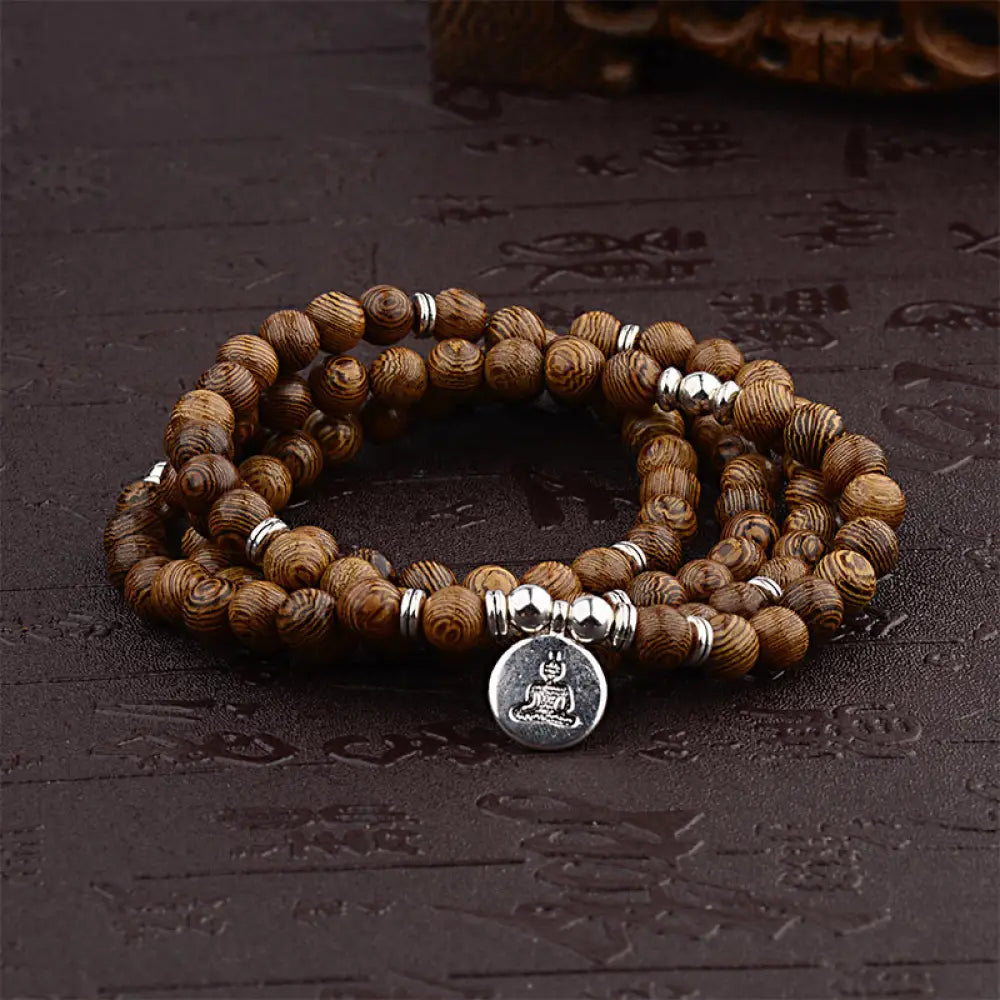 A BWOOOH Tibetan Lightning Strike Wood Mala Bracelet, 46cm circumference, featuring distinct lightning bolt markings, accented with a silver-colored Lotus symbol and a peaceful Buddha charm. - View 2