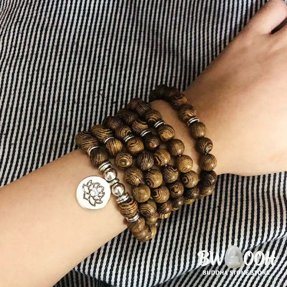 A BWOOOH Tibetan Lightning Strike Wood Mala Bracelet, 46cm circumference, featuring distinct lightning bolt markings, accented with a silver-colored Lotus symbol and a peaceful Buddha charm. - View 6