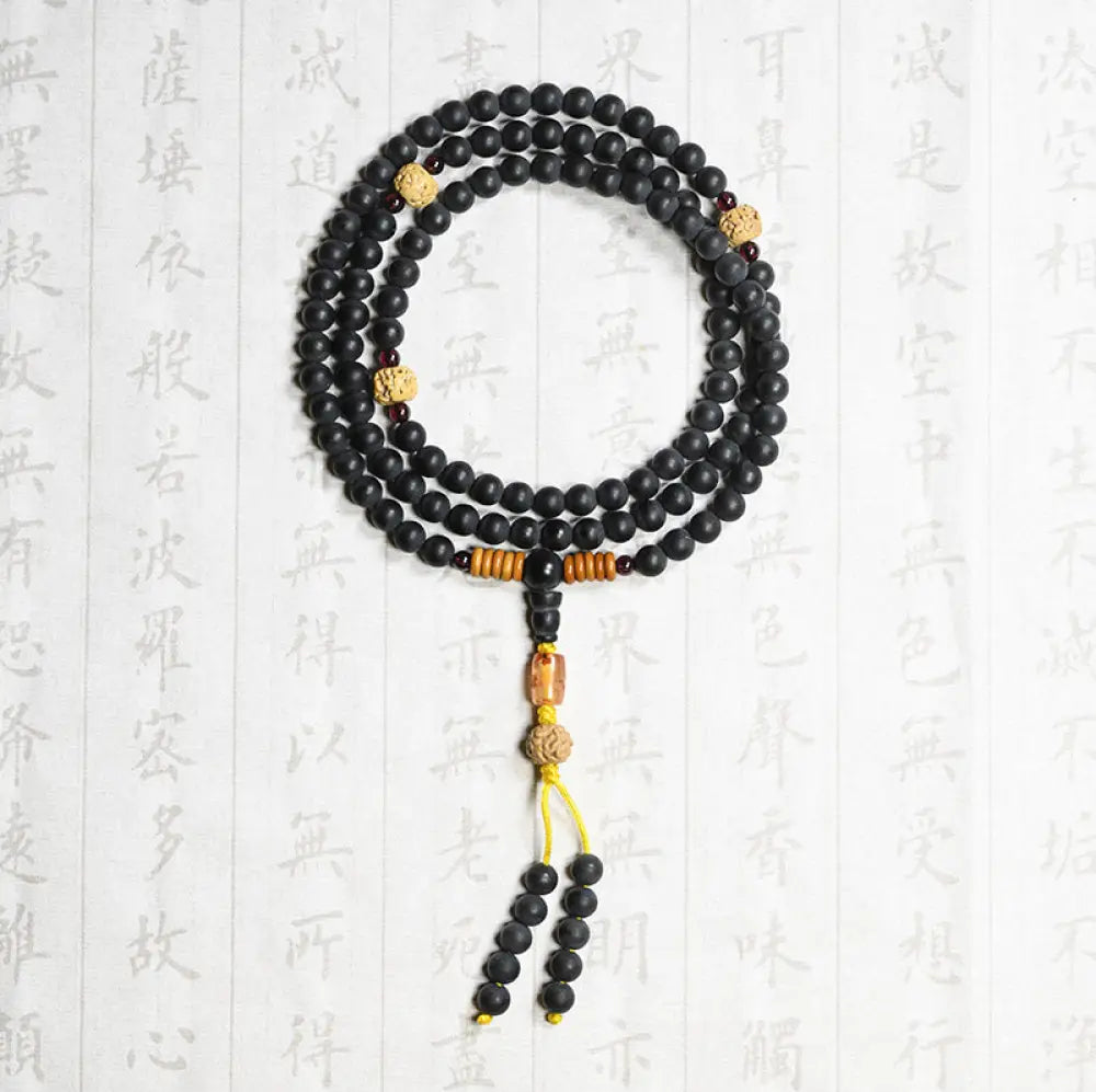 BWOOOH authentic Tibetan Mala bracelet or necklace crafted with 108 polished Cypress beads, distinctive dark-speckled Bodhi Seeds, vibrant Red Agate, and deep Garnet accents, embodying spiritual protection and healing energy. - View 3