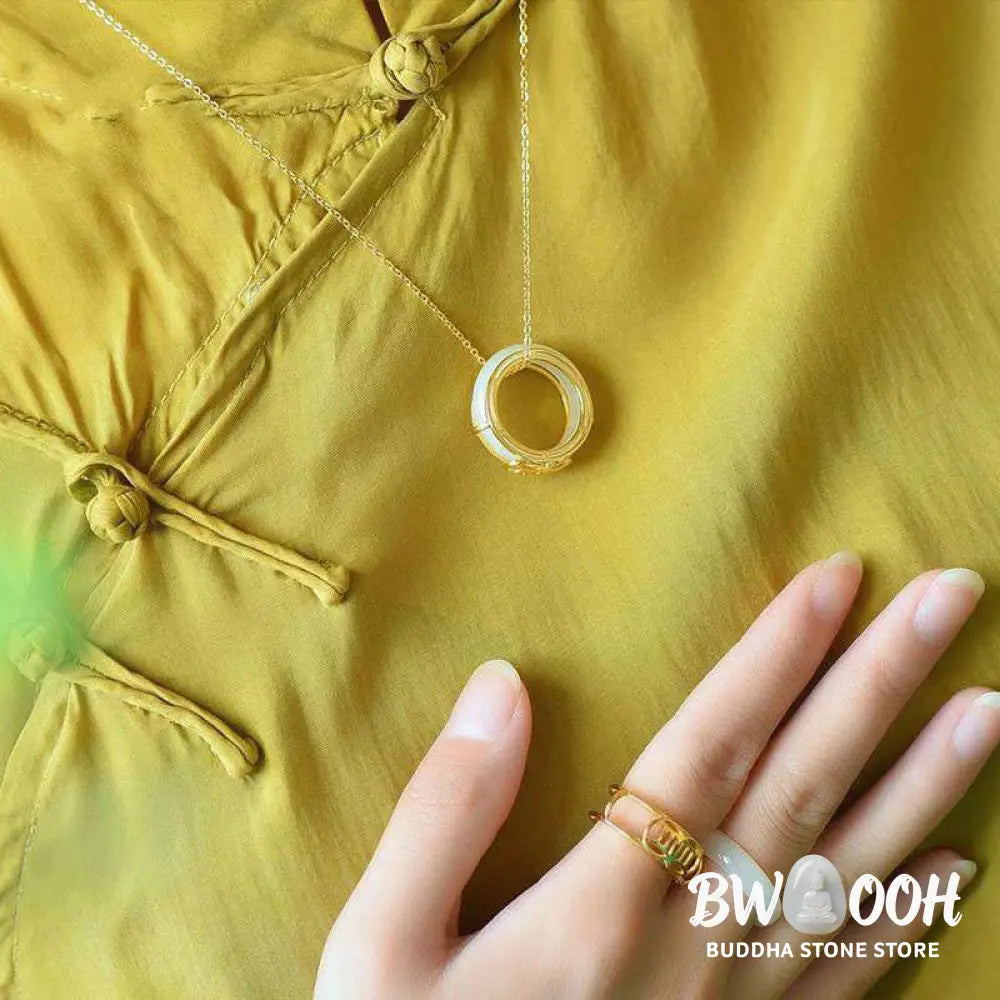 BWOOOH White Jade Luck Ring Necklace featuring a smooth white jade ring, intricately wrapped in copper wire with a prominent lucky knot symbol. The versatile piece is shown as a spiritual pendant on its included chain, suitable for unisex wear. - View 5
